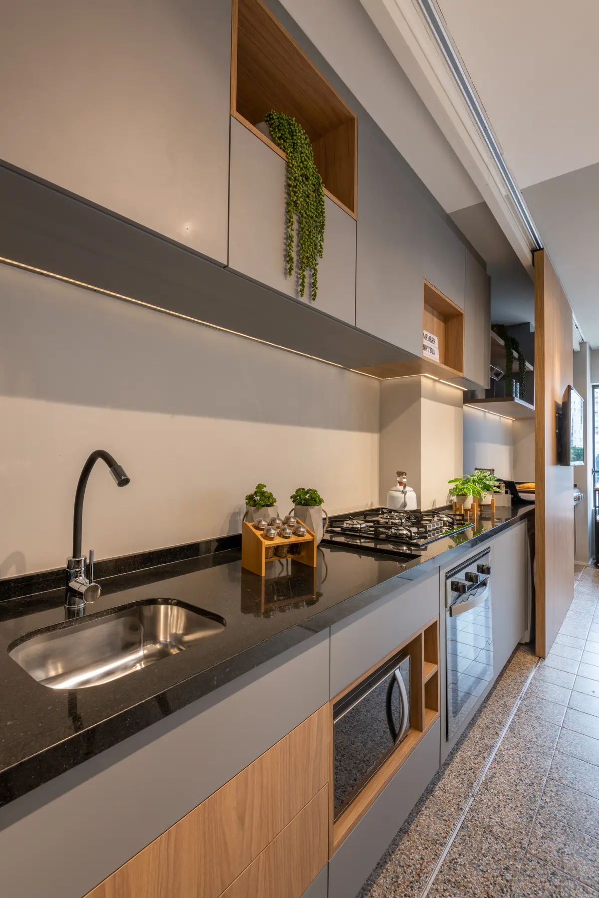Cocina moderna con mesada negra, muebles blancos y detalles en madera natural — proyecto Brick 1, por Pricila Dalzochio
