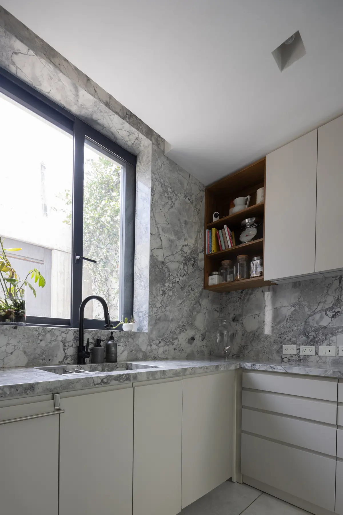 Cocina moderna minimalista con revestimiento de mármol y muebles blancos — proyecto CASA OrBa, por Alfredo Orfila arquitectura, en San Isidro