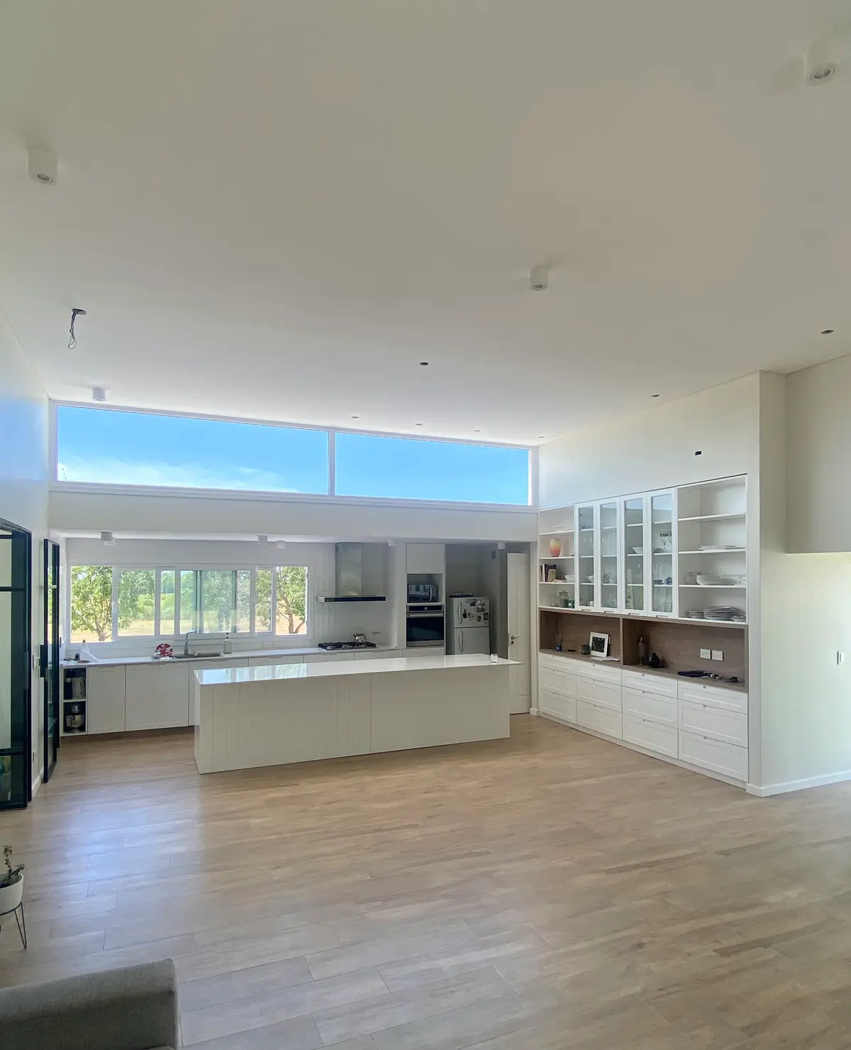 Cozinha moderna de pé-direito duplo com ilha minimalista e janelas amplas — projeto Casa Cardales, por Hernan Goldfarb, em Belén de Escobar