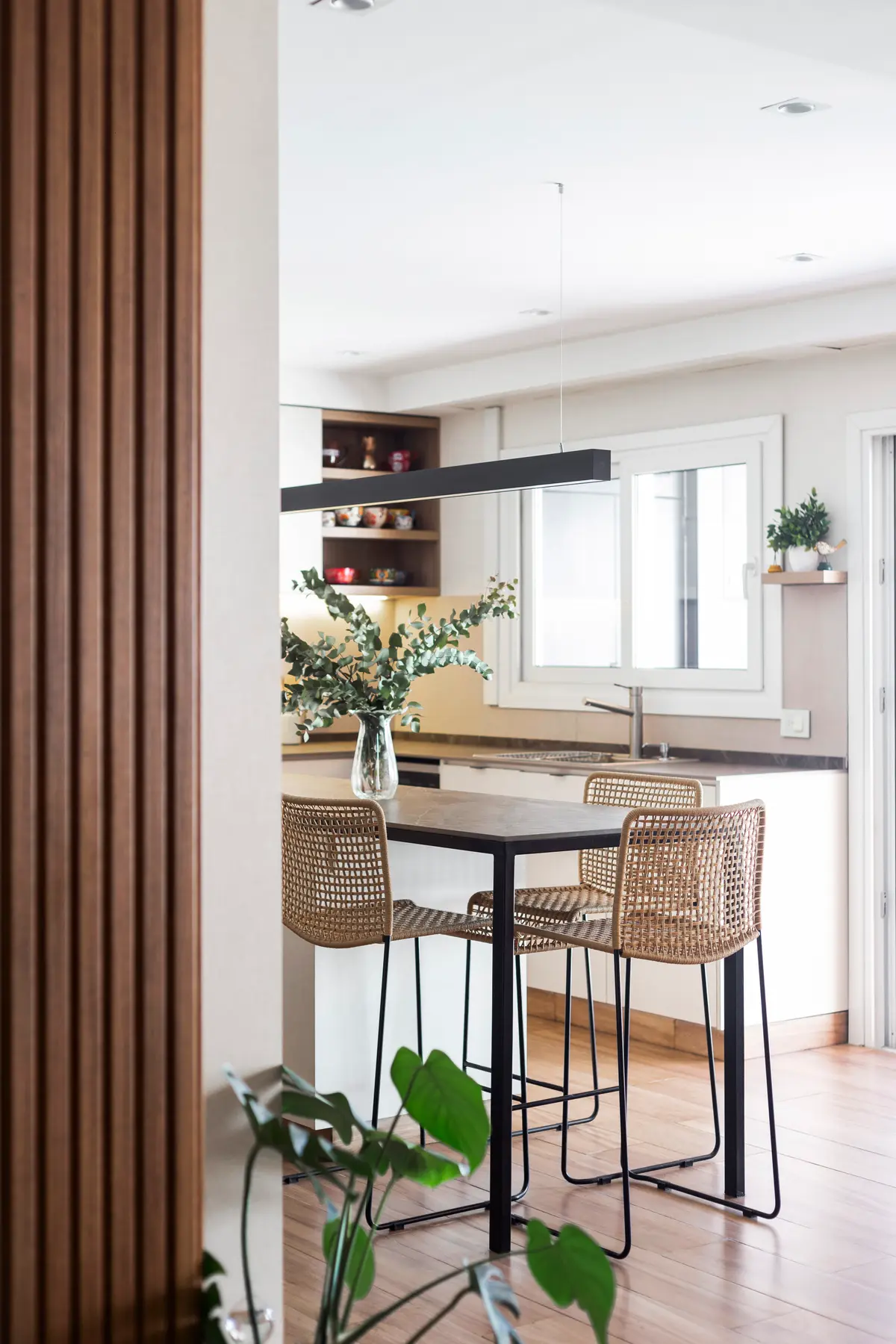 Cozinha moderna com parede de ripas de madeira e sala de jantar integrada — projeto Casa en Martinez, por JT ARQUITECTURA, em Martínez