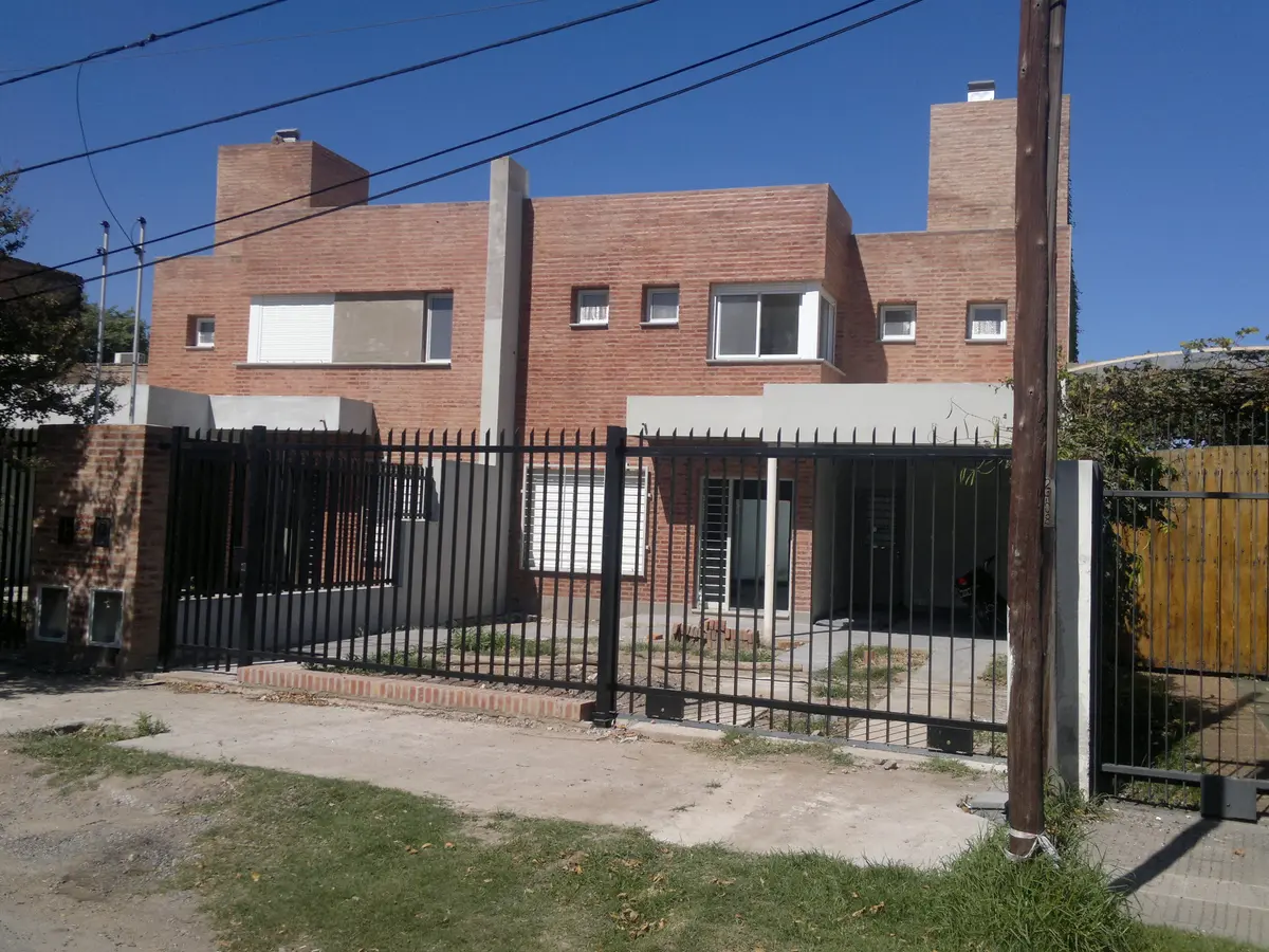 fachada moderna de ladrillo con rejas metalicas — proyecto Duplex granja de Funes, por Gustavo Gurvich Arquitecto, en Córdoba