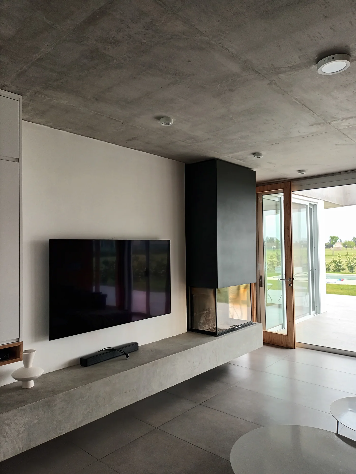 Living moderno con techo de hormigón y chimenea integrada