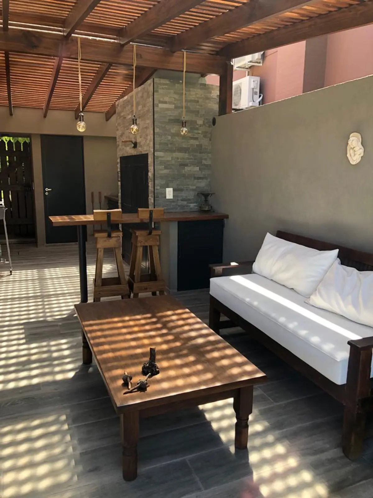 Dormitorio con cama blanca, mesa de luz y techo de listones de madera — proyecto Pilar, por Rioja Arquitectura, en Pilar