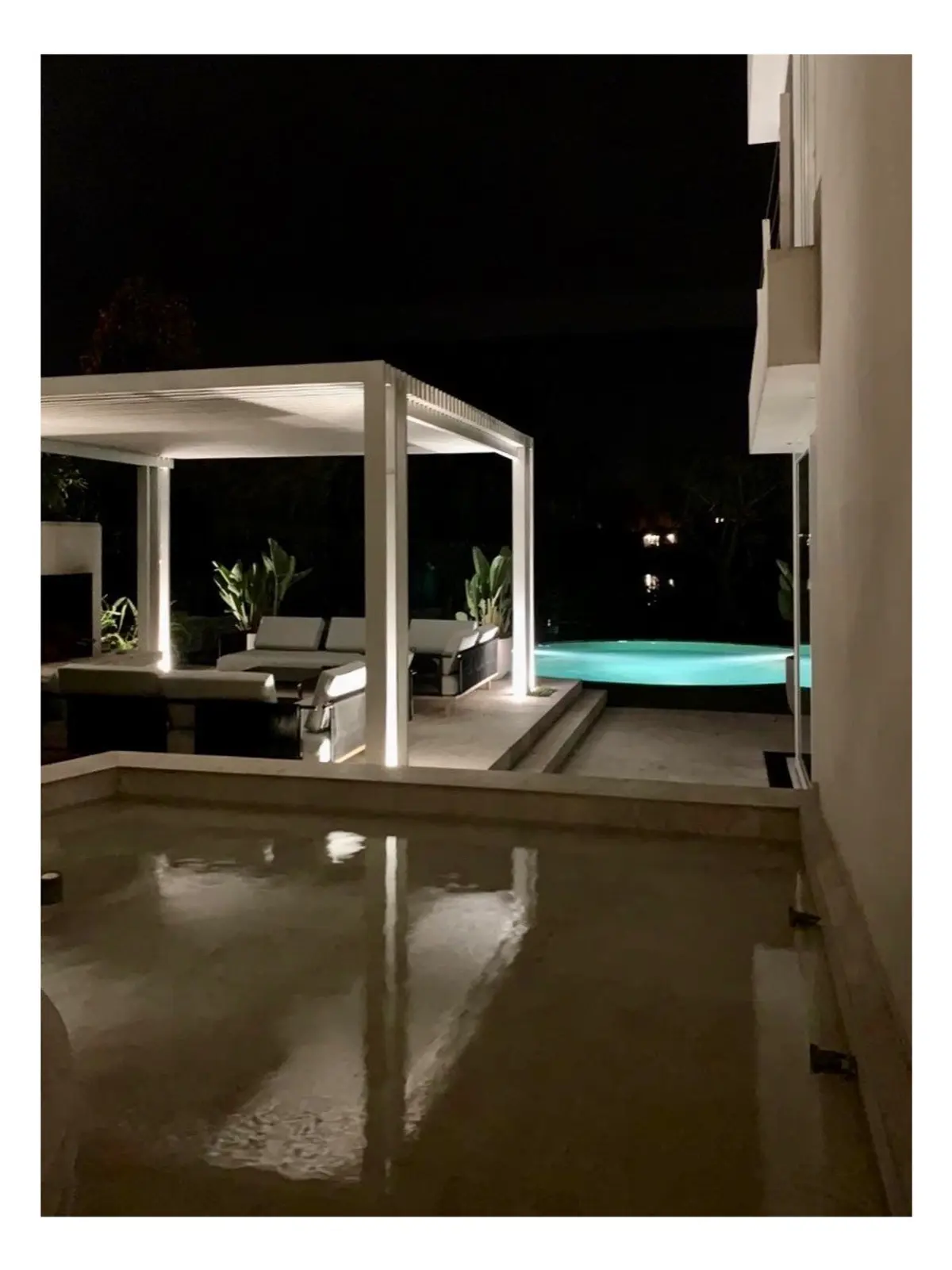 espacio exterior nocturno con piscina y pérgola minimalista — proyecto CASA LAGUNA, por Estudio Xime Fontan Balestra, en Tigre