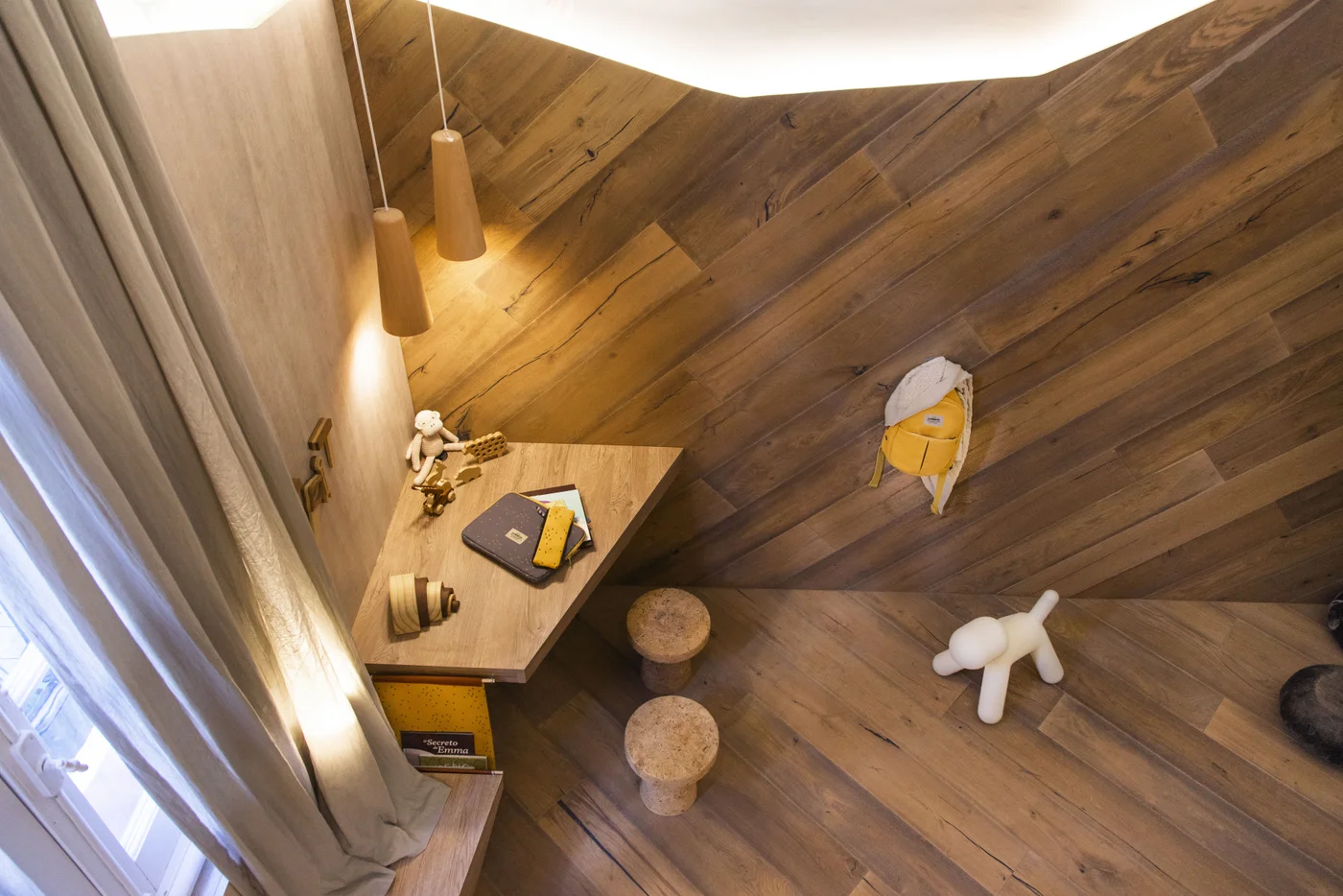 Espacio de trabajo moderno con pared de madera en listones diagonales y escritorio geométrico.