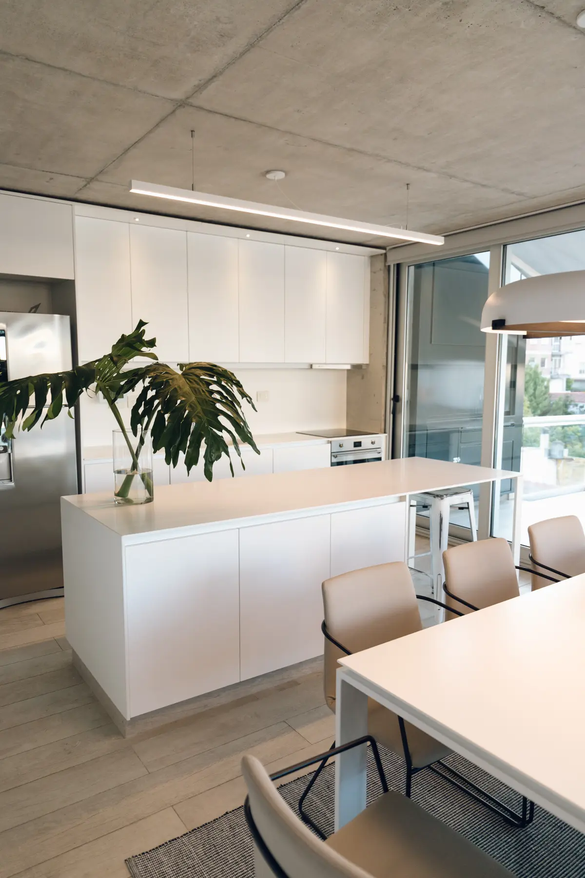 Cocina moderna minimalista con isla, terminaciones en blanco y concreto — proyecto Departamento Nuñez, por Estudio CDW, en Núñez
