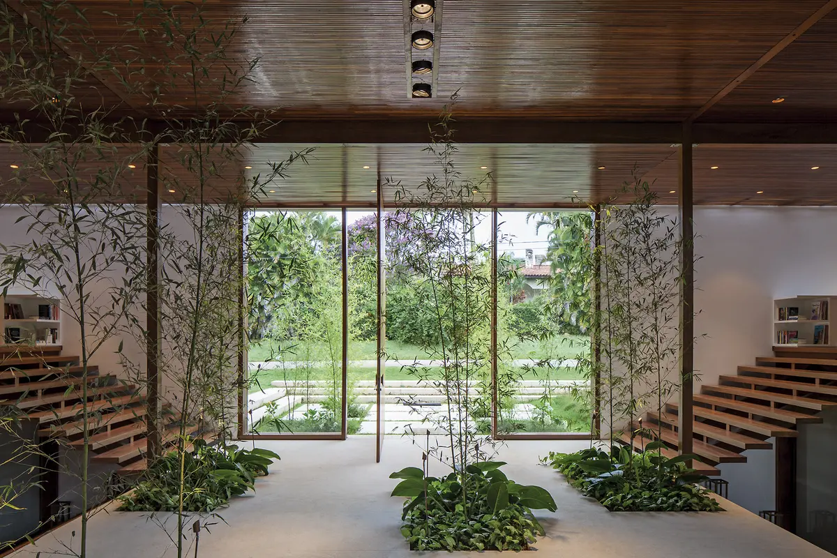 Pasillo luminoso con escaleras de madera y jardin vertical interior — proyecto Residência GS, por Gil Fialho