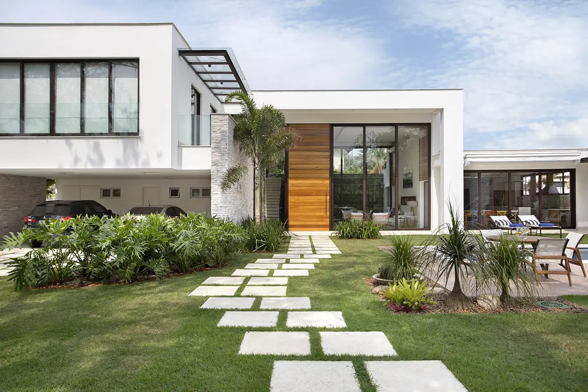 Casa moderna con fachada blanca, ventanas de piso a techo y piscina — proyecto Casa Jardim Ubá, por Amanda Miranda