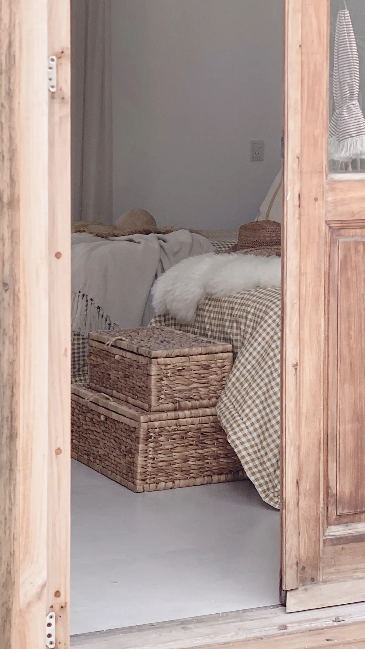 Dormitorio boho escandinavo con cestas tejidas y sombreros de paja — proyecto El Refugio, por Grupo Pauta Arquitectura, en Pinamar