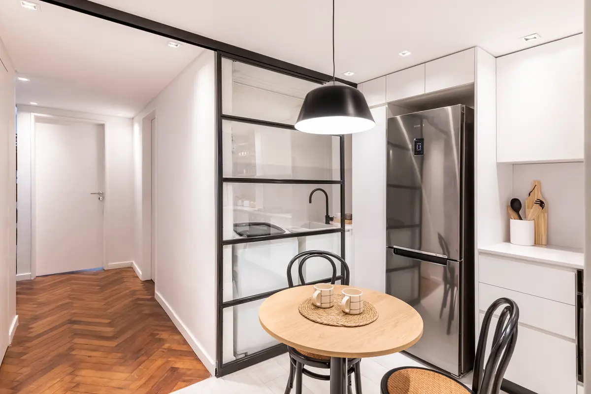 Cocina y comedor modernos con isla y luz colgante negra — proyecto Libertad, por Estudio Basa, en Buenos Aires