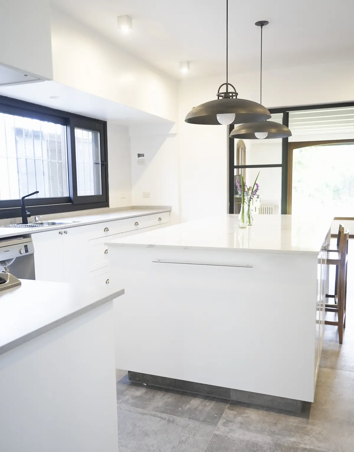 Cozinha moderna com ilha branca, luminárias pendentes industriais — projeto Obra Isabel la Católica P, por Arq. Lourdes Yarade Saravia, em San Isidro