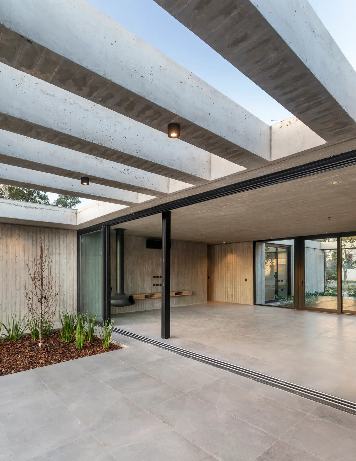 Residencia moderna brutalista con vigas de hormigón y espacio interior-exterior — proyecto Casa ROMA, por V2 Arquitectos, en City Bell