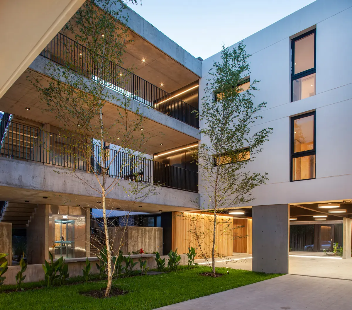 Fachada moderna de edificio de apartamentos con balcones y vegetación — proyecto Alvear AV, por V2 Arquitectos, en City Bell