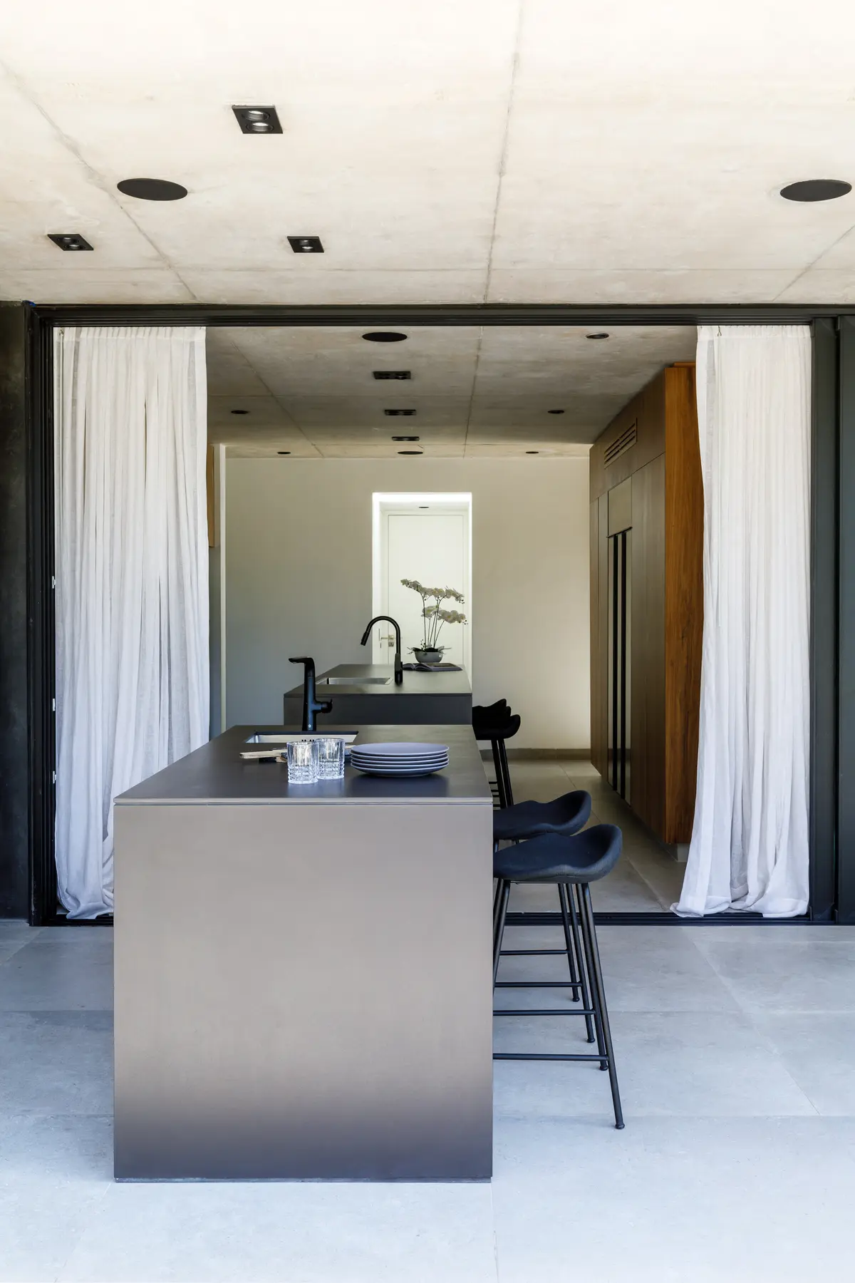 Cocina moderna minimalista con isla de hormigón y metal — proyecto CASA AH, por GMARQ, en Garin