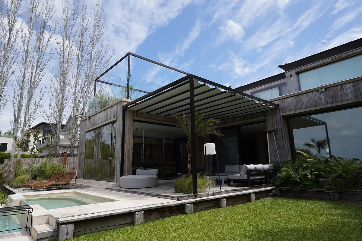 fachada moderna de madeira com pergolado e piscina — projeto TOLDER - PERGOLAS, por Argentina en Obra 2024, em Rincón de Milberg