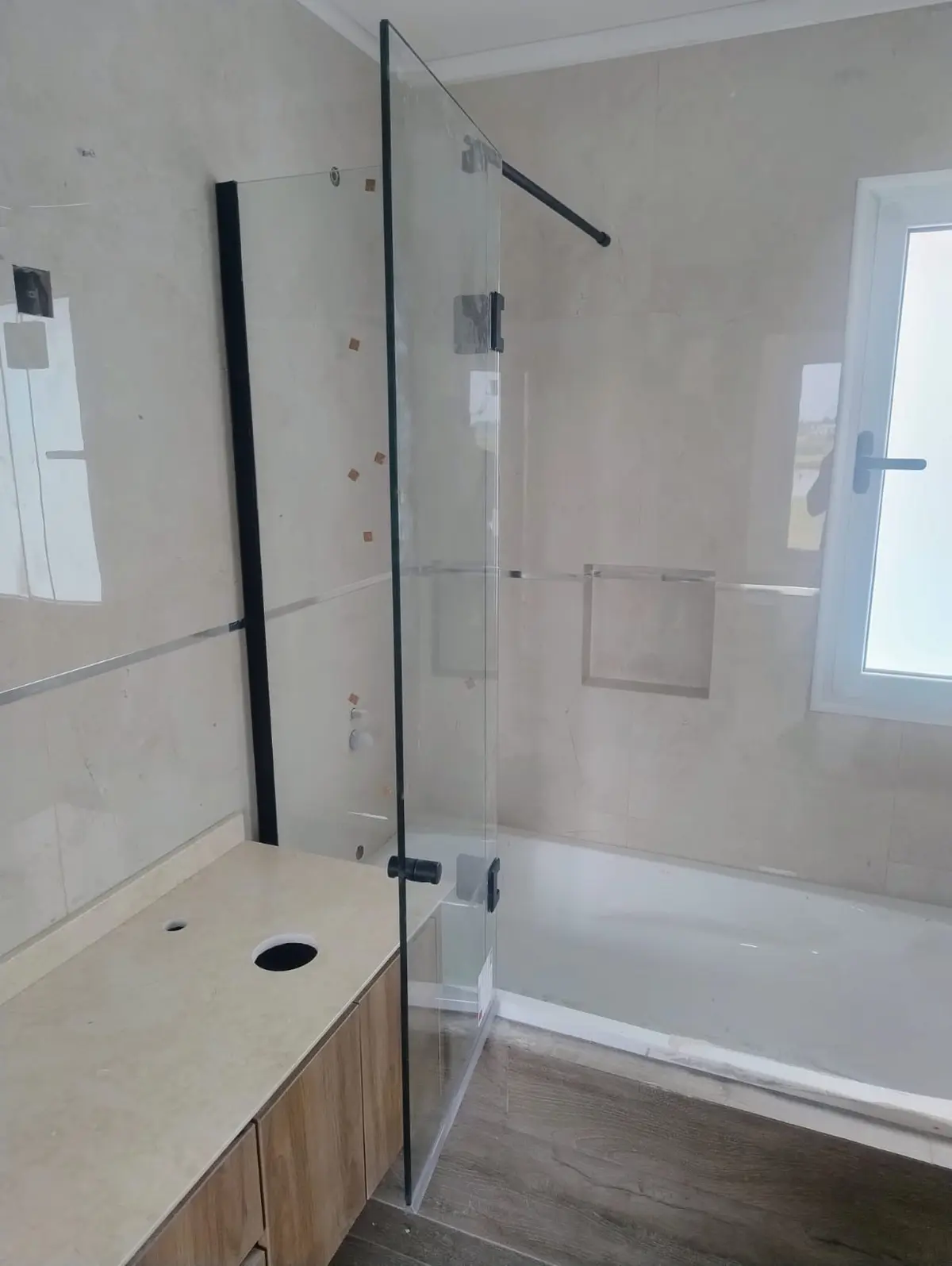 Banheiro moderno minimalista com banheira freestanding e box de vidro — projeto Mampara paño fijo + rebatible, por Cristalcenter, em Belén de Escobar