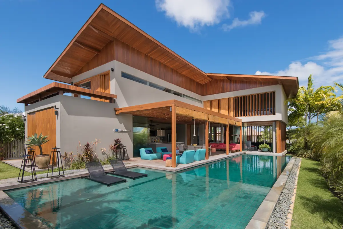 Casa moderna com piscina infinita e detalhes em madeira — projeto Casa RJ Praia do Forte, por Architects + Co