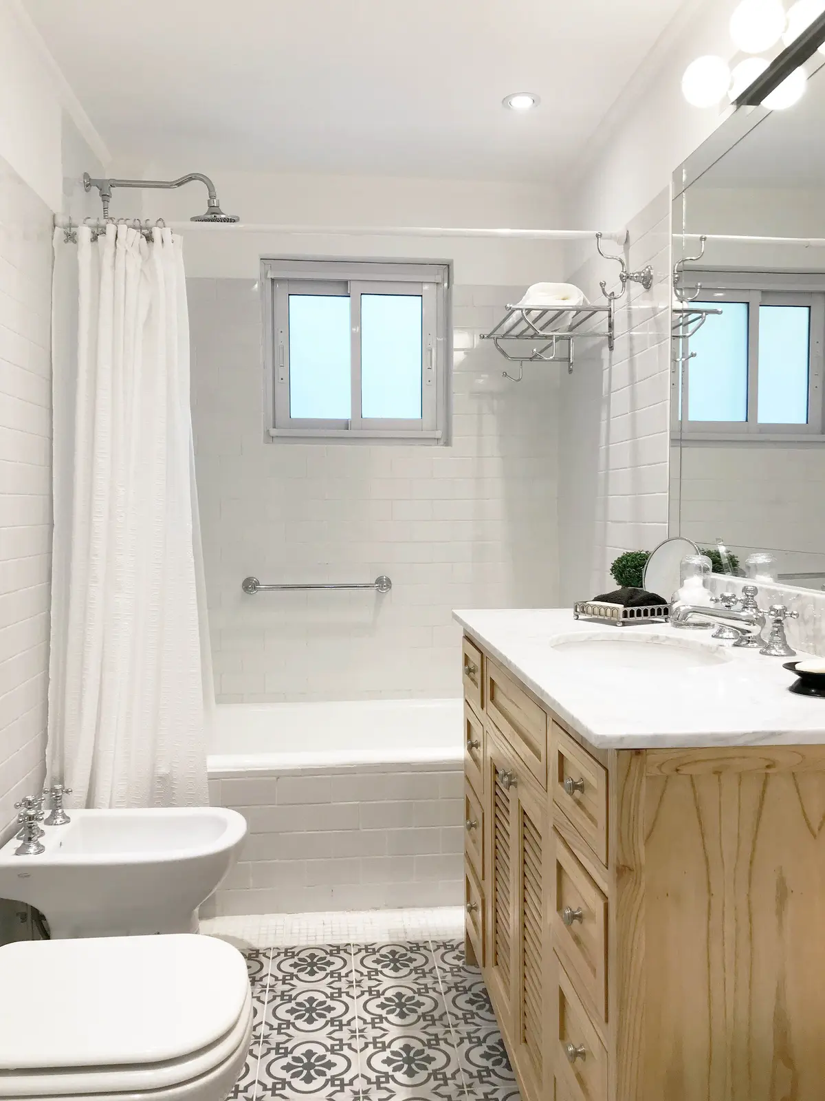 Baño clásico moderno con bidet, inodoro, vanitory de madera y ducha — proyecto Obra Alberdi, por Estudio Nicolás Pierry, en CABA