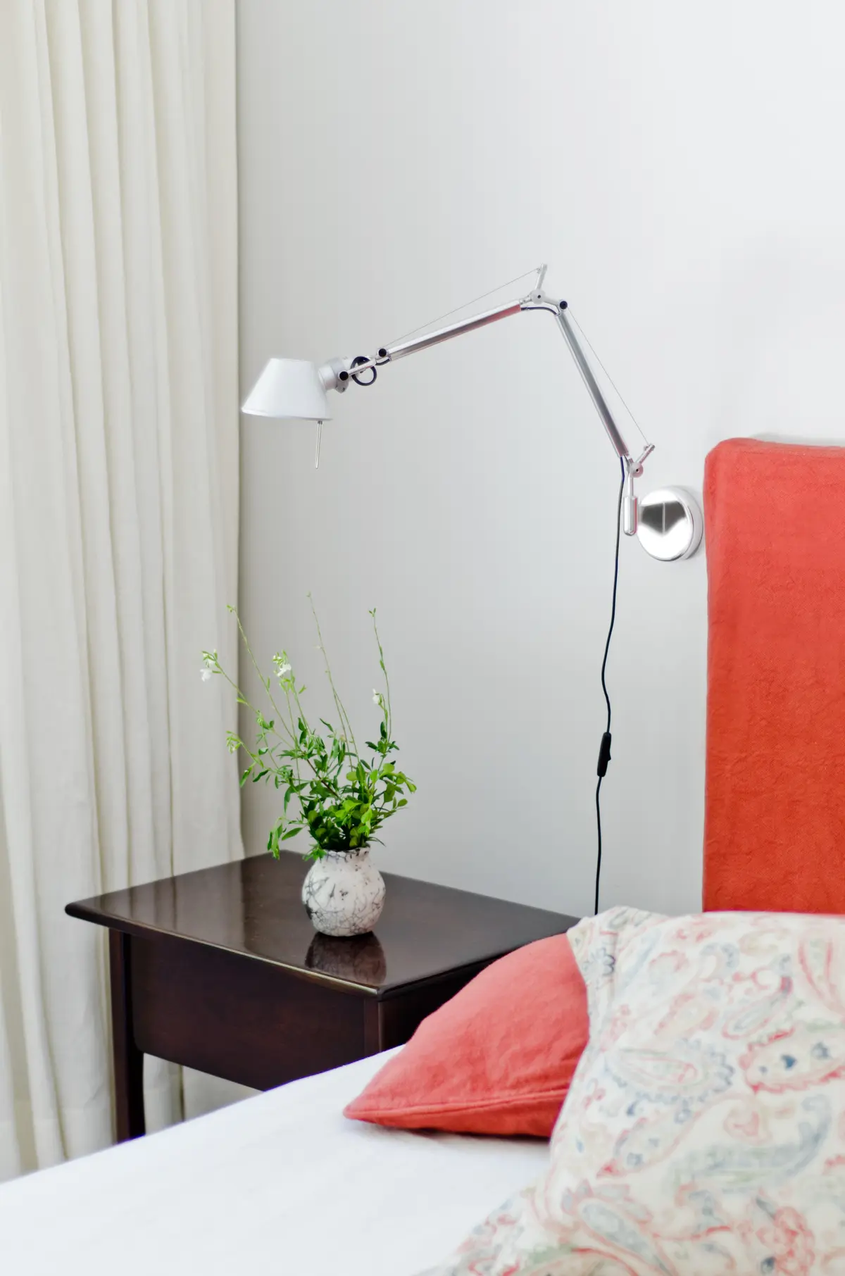 Dormitorio moderno con lámpara de pared articulada y cabecero rojo — proyecto Casa P, por Estudio Dado, en San Isidro