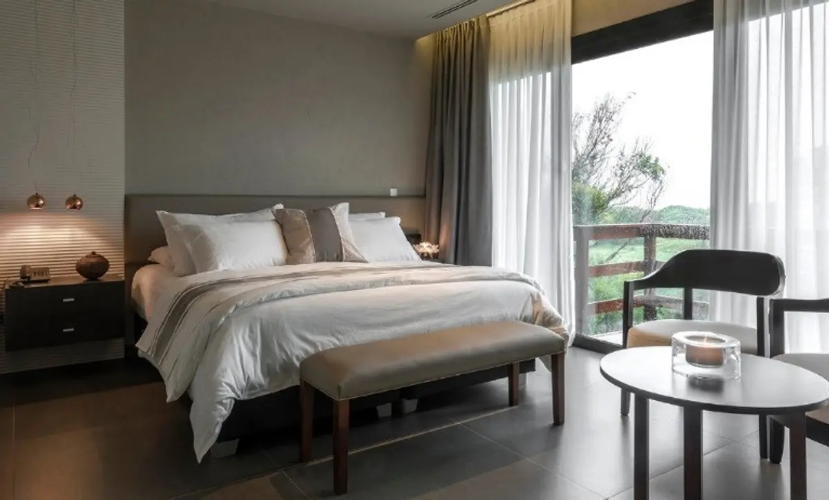 Quarto de hotel moderno com amplas janelas e vista rural — projeto Spa Ville St Germain, por Estudio de Int Diana Gradel, em Cariló