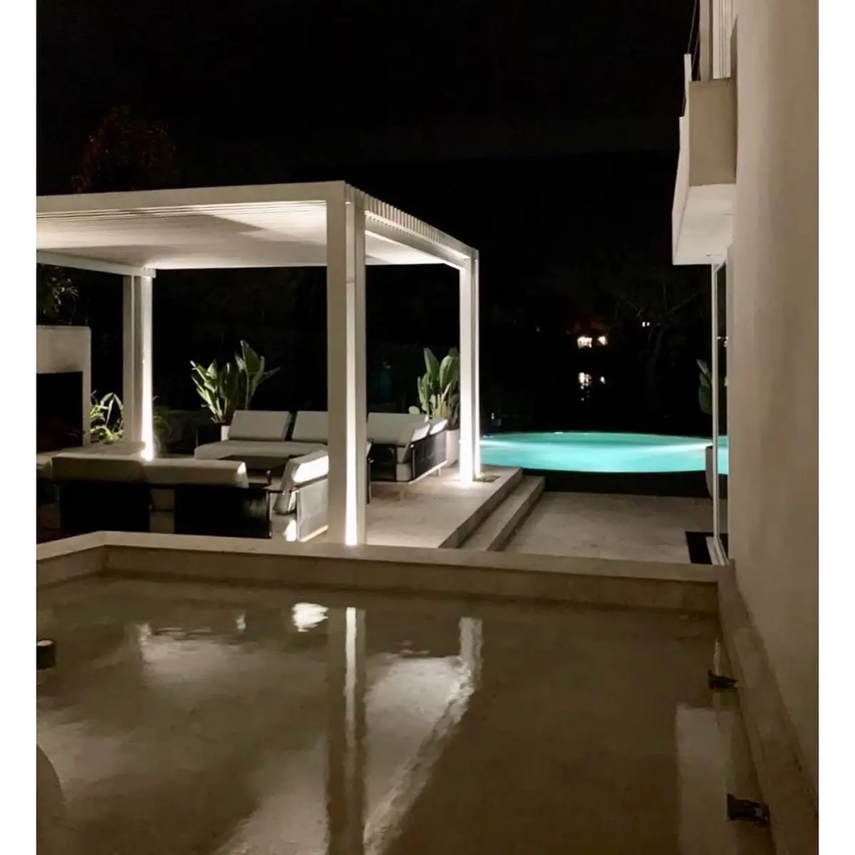 terraza moderna con piscina y pérgola iluminada de noche — proyecto CASA LAGUNA, por Estudio Xime Fontan Balestra, en Tigre