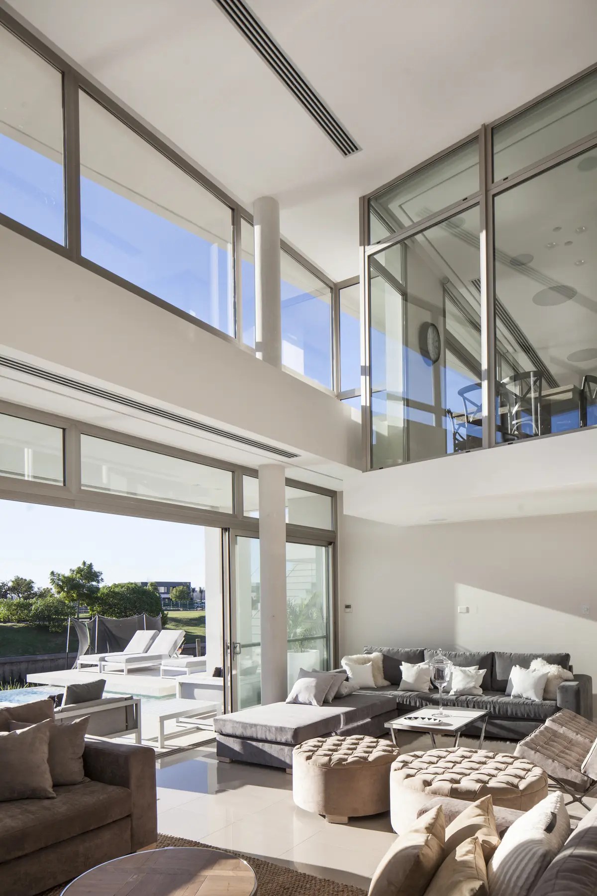 Living moderno de doble altura con ventanales y vista a la costa — proyecto Casa Caledoiscopio, por Apaarquitectura, en Nordelta