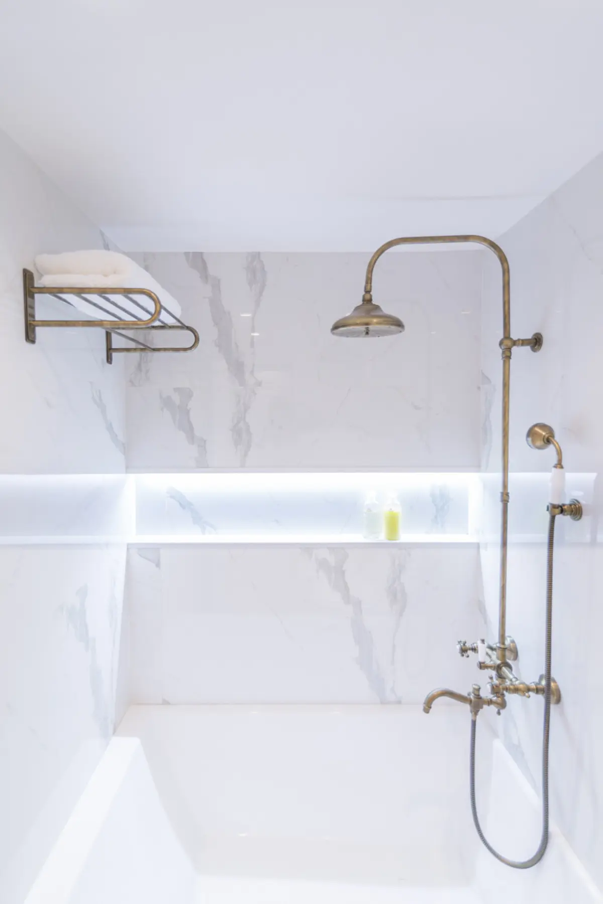 baño clásico con ducha de latón y bañera blanca — proyecto Arce 943, por ST Arquitectas, en CABA
