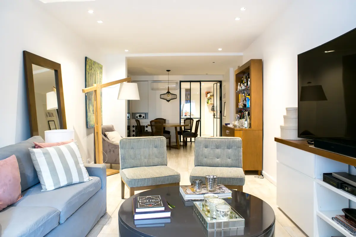 Living moderno con sofá gris, mesa ratona redonda y comedor integrado — proyecto Callao, por Mgc.arq, en CABA