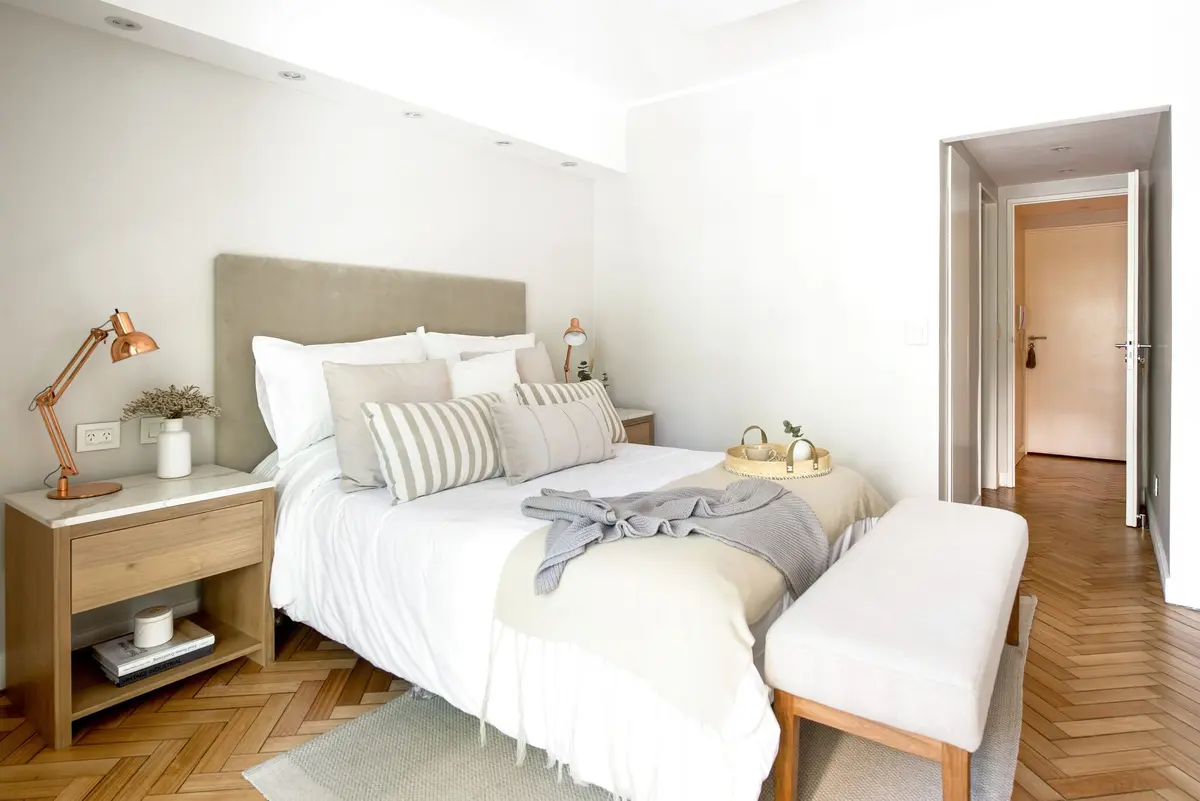 Dormitorio moderno con cama, parquet y lámpara cobre — proyecto Libertador, por Efg Estudio Filcman Gurfinkiel, en CABA