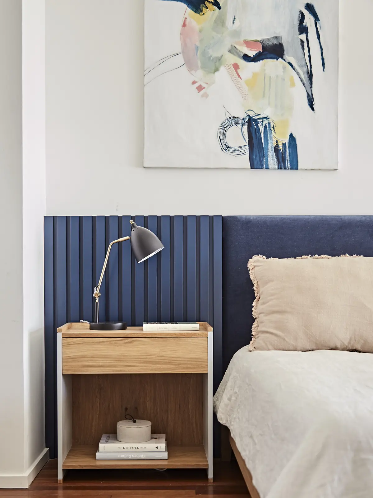 Habitación con arte abstracto, pared de listones de madera y cama de lino — proyecto Proyecto Arboris, por URBANO estudio, en San Isidro