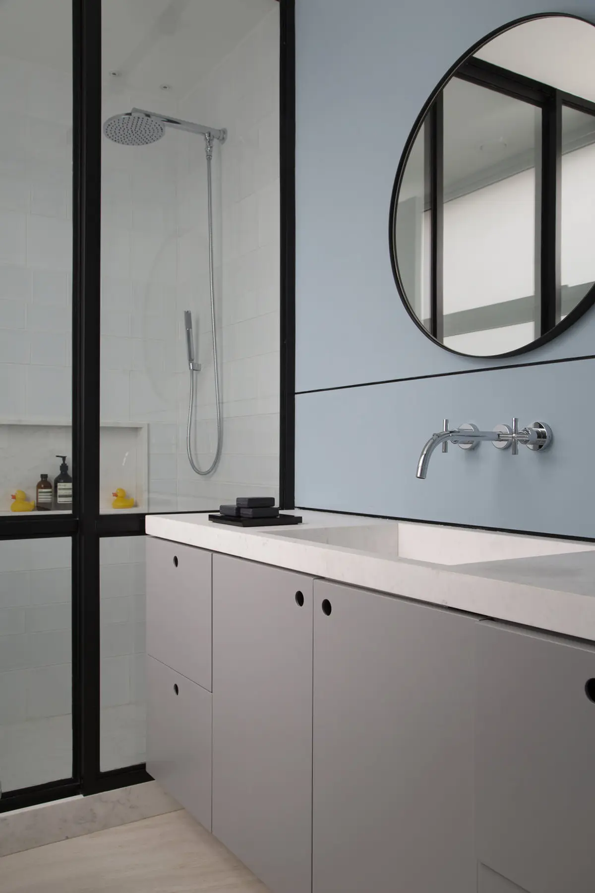 Bano minimalista con mesada de marmol blanco y espejo circular negro — proyecto PS House, por Studio Ro-ca
