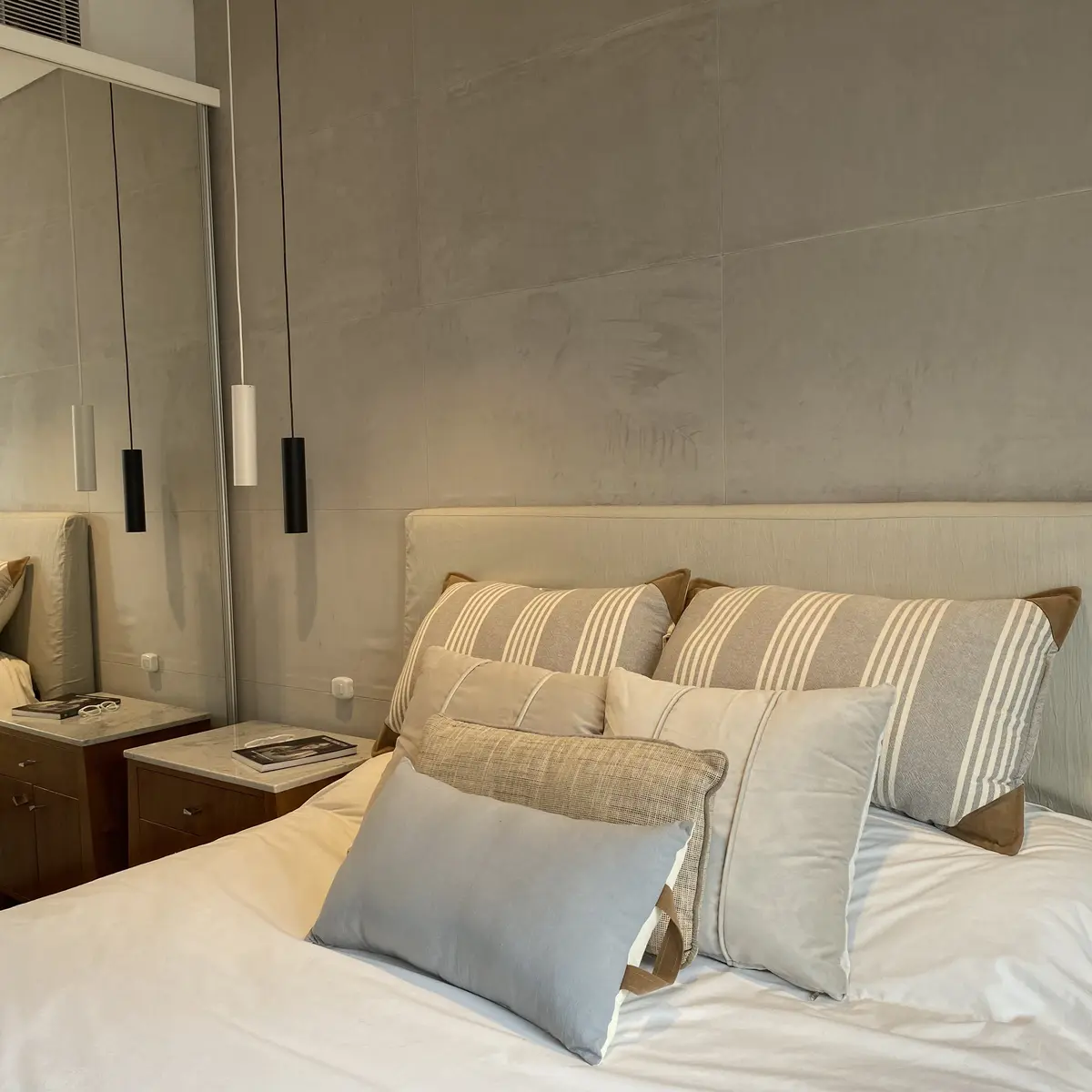 Quarto moderno com paredes de microcimento e luminárias pendentes — projeto Juncal, por MDBK Arquitectura, em Recoleta
