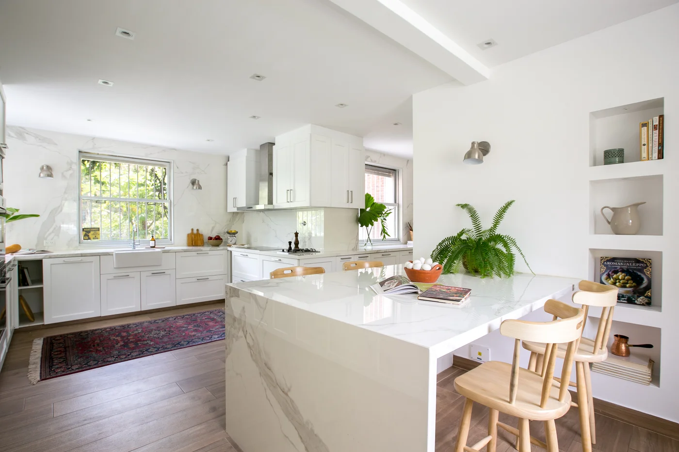 Cocina moderna abierta con isla de mármol y mucha luz