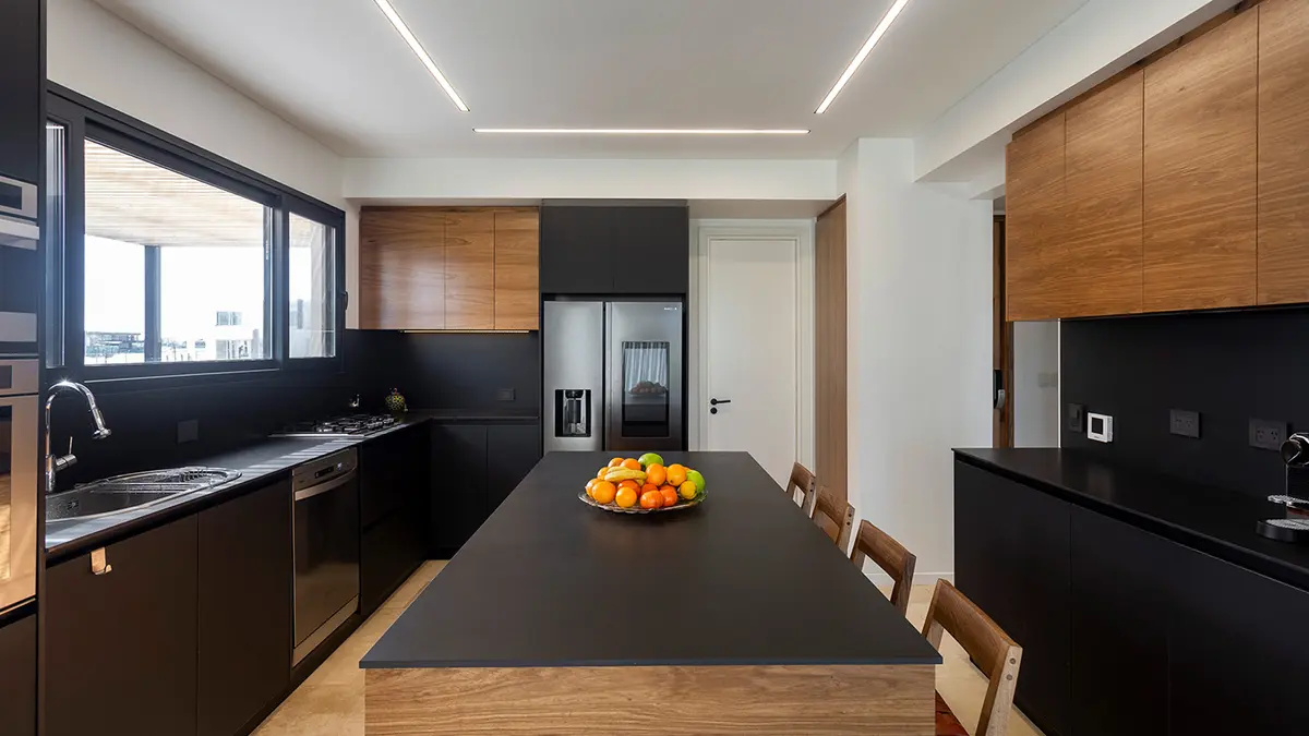 Cozinha moderna minimalista com ilha preta e detalhes em madeira — projeto RIBERAS II, por BCH ARQUITECTURA