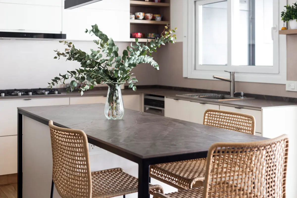 Cozinha escandinava moderna com ilha de cimento e cadeiras de rattan — projeto Casa en Martinez, por JT ARQUITECTURA, em Martínez