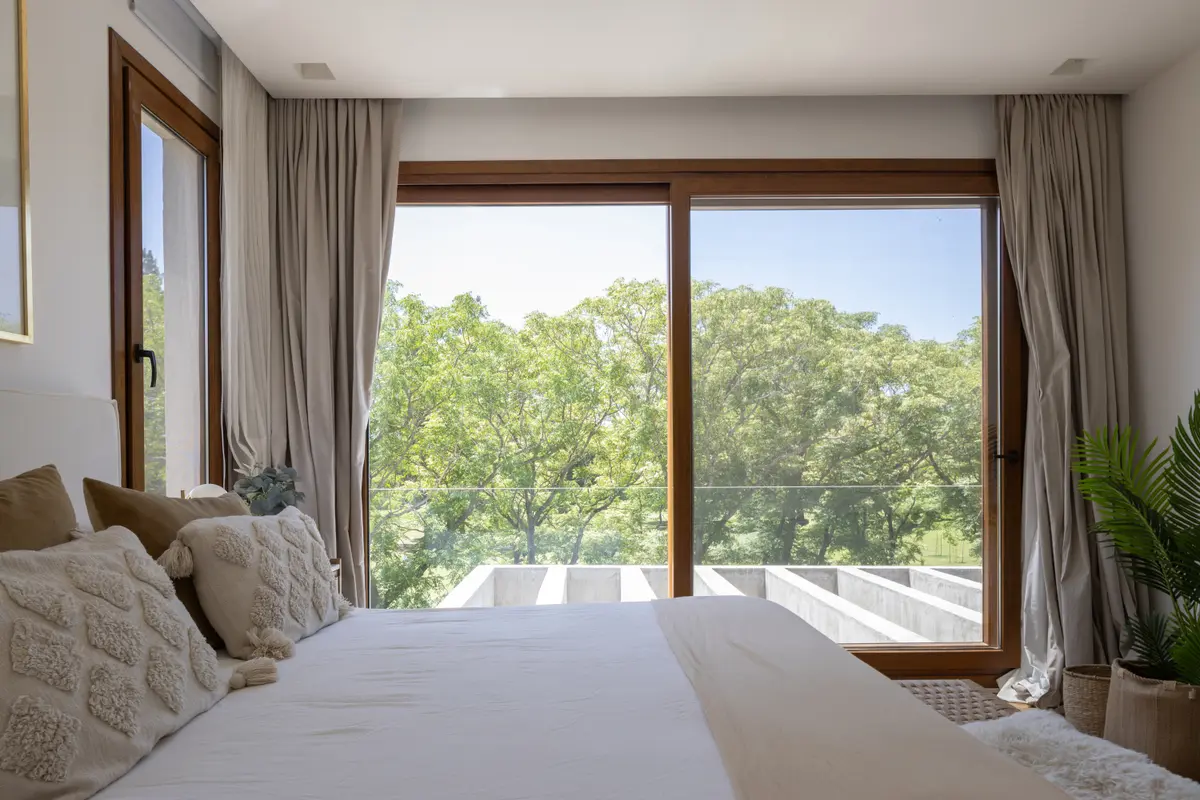 Quarto moderno com grande janela para floresta e cama texturizada — projeto CASA BaCa, por Alfredo Orfila arquitectura, em Benavidez