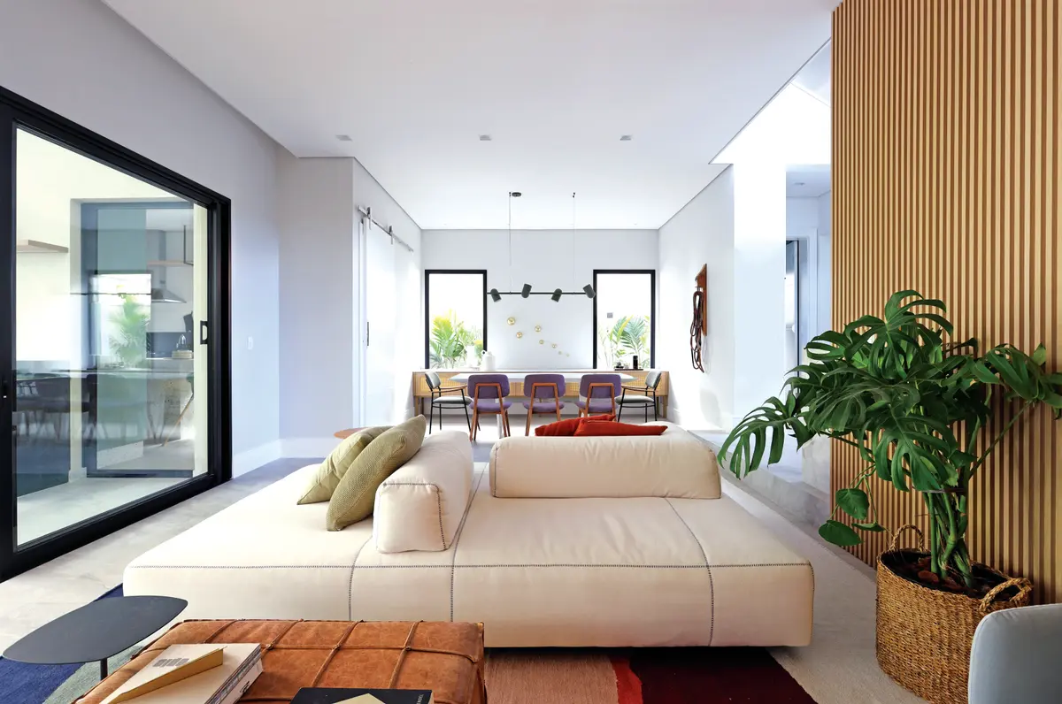 Render de sala de estar e jantar integrados com sofá bege e mesa de madeira — projeto Projeto Destaque Club&Casa, por Barbara Dundes – Arquitetura + Design