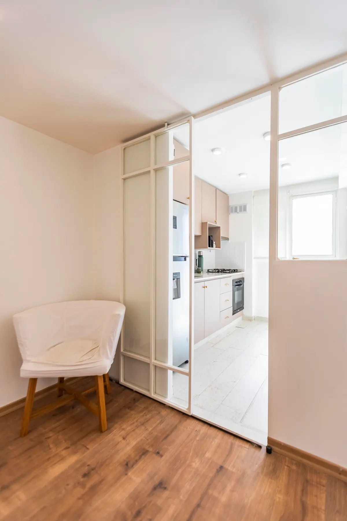 Cocina moderna con acceso a sala de estar, piso de madera y separador de vidrio — proyecto Remodelacion departamento en Belgrano, por MSMC, en Buenos Aires