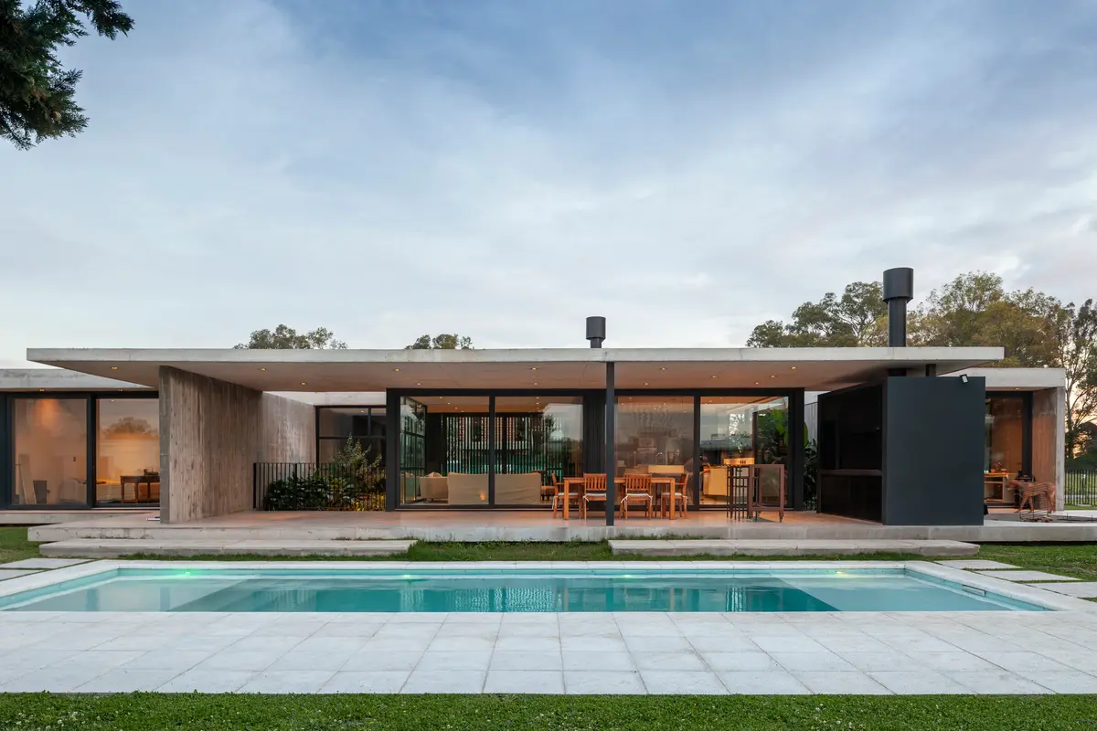 Casa moderna com telhado de concreto em balanço e piscina — projeto Casa GUGA, por V2 Arquitectos, em City Bell