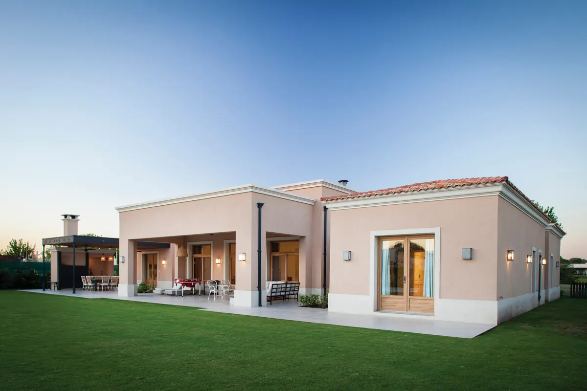 Fachada de casa mediterrânea moderna com pátio e pergolado — projeto Casa en Pilará, por Mazzinghi Sanchez