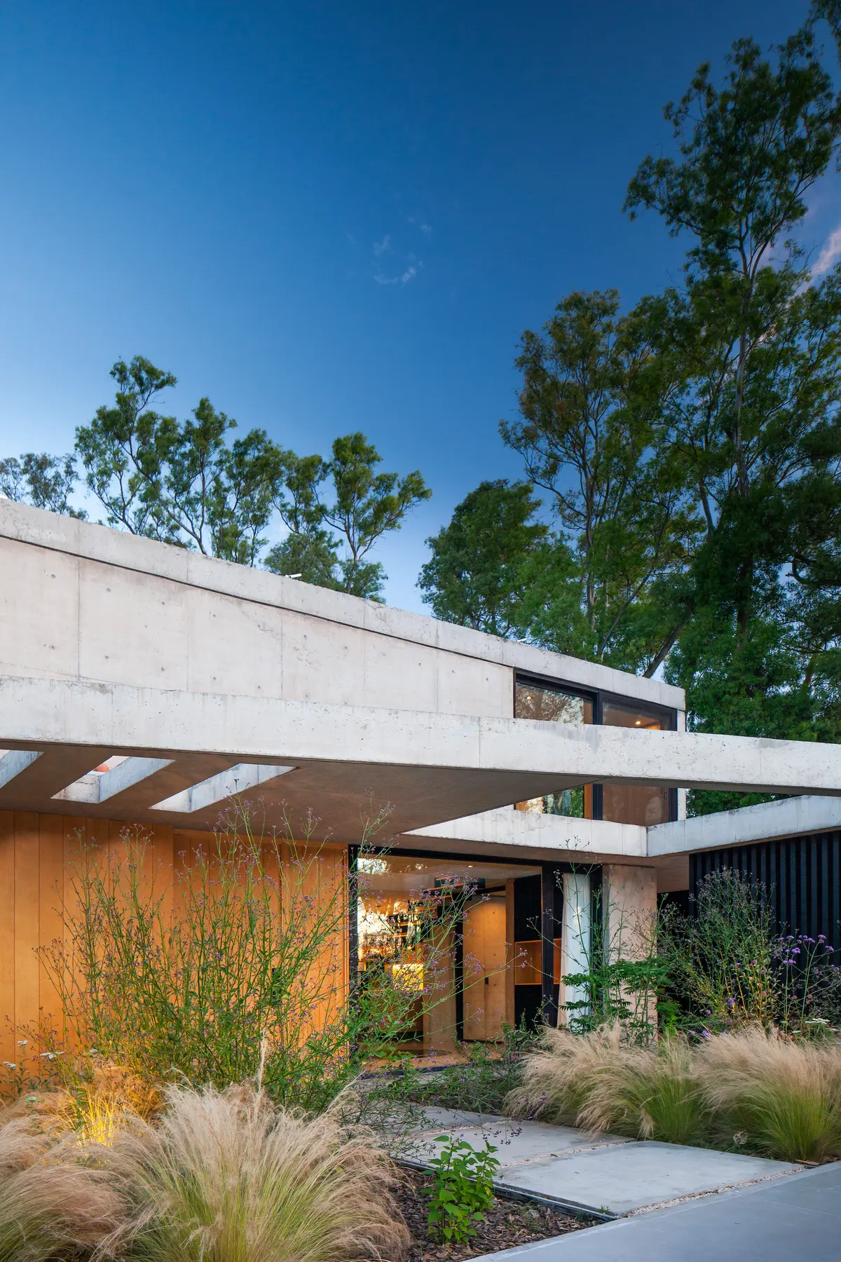 Fachada minimalista de casa moderna com concreto e madeira — projeto Casa ALVA, por V2 Arquitectos, em City Bell