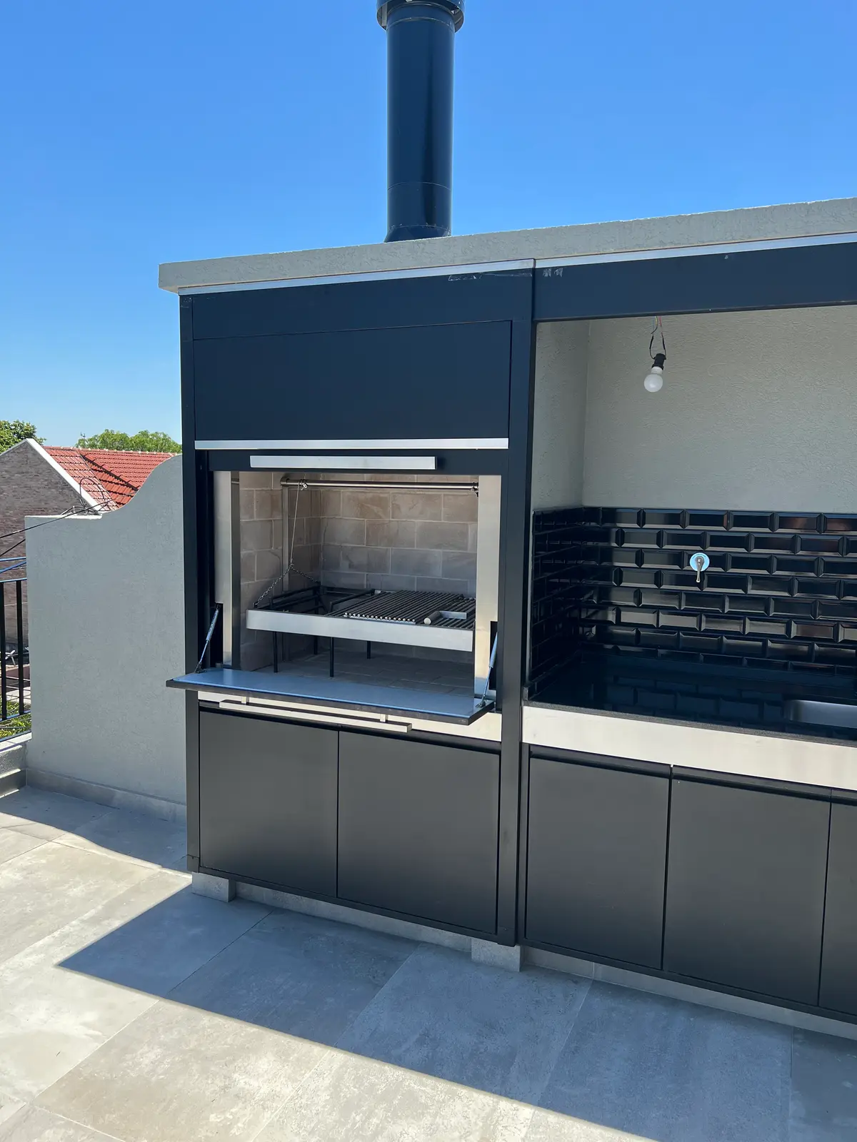 área gourmet moderna com churrasqueira e armários pretos — projeto DEPTO MARTINEZ, por Estudio Grupo 32, em Martínez