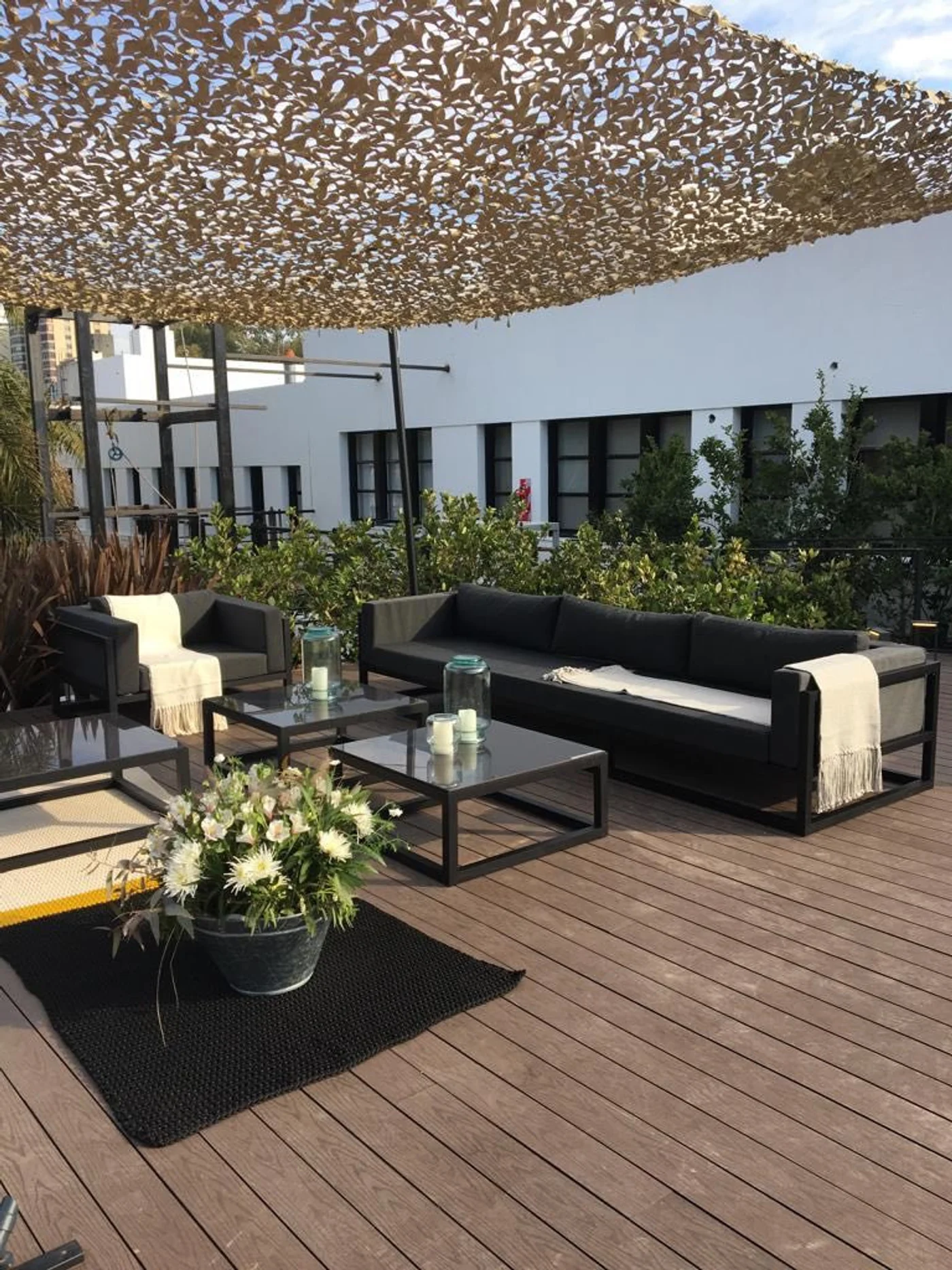 terraza moderna con lona de camuflaje y muebles negros
