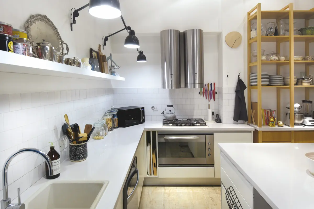 Cocina minimalista blanca con isla central, muebles de madera y estanterías abiertas — proyecto Callao, por Estudio Diez Muzzio, en CABA