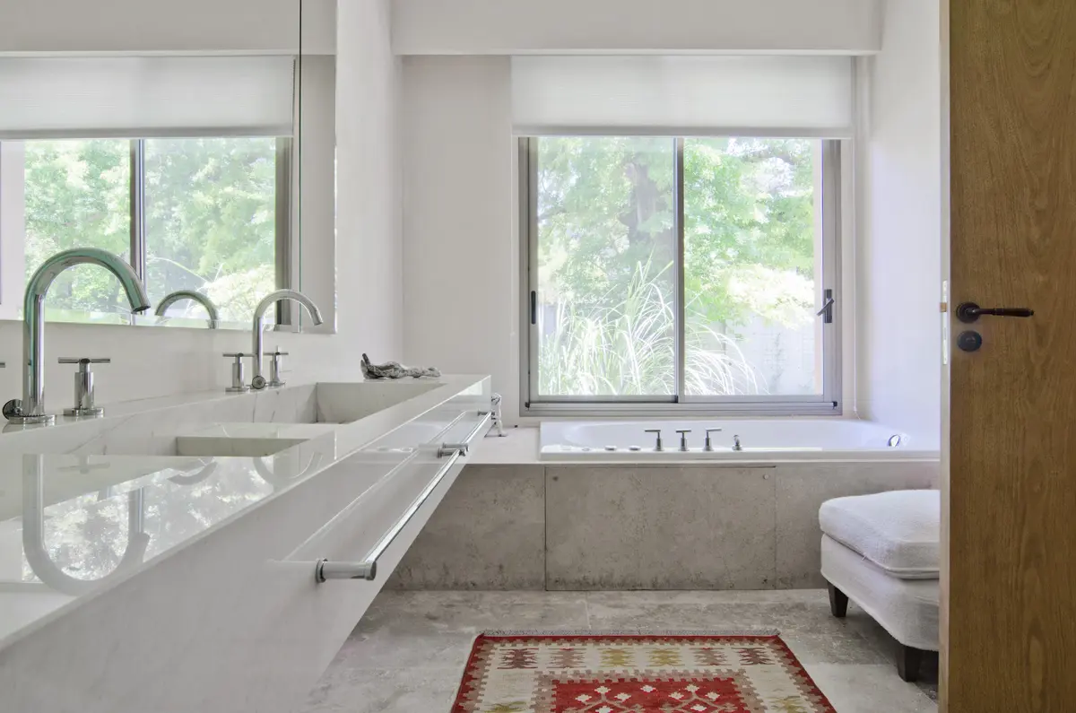 Baño moderno con doble bacha integrada y bañera exenta — proyecto Casa P, por Estudio Dado, en San Isidro