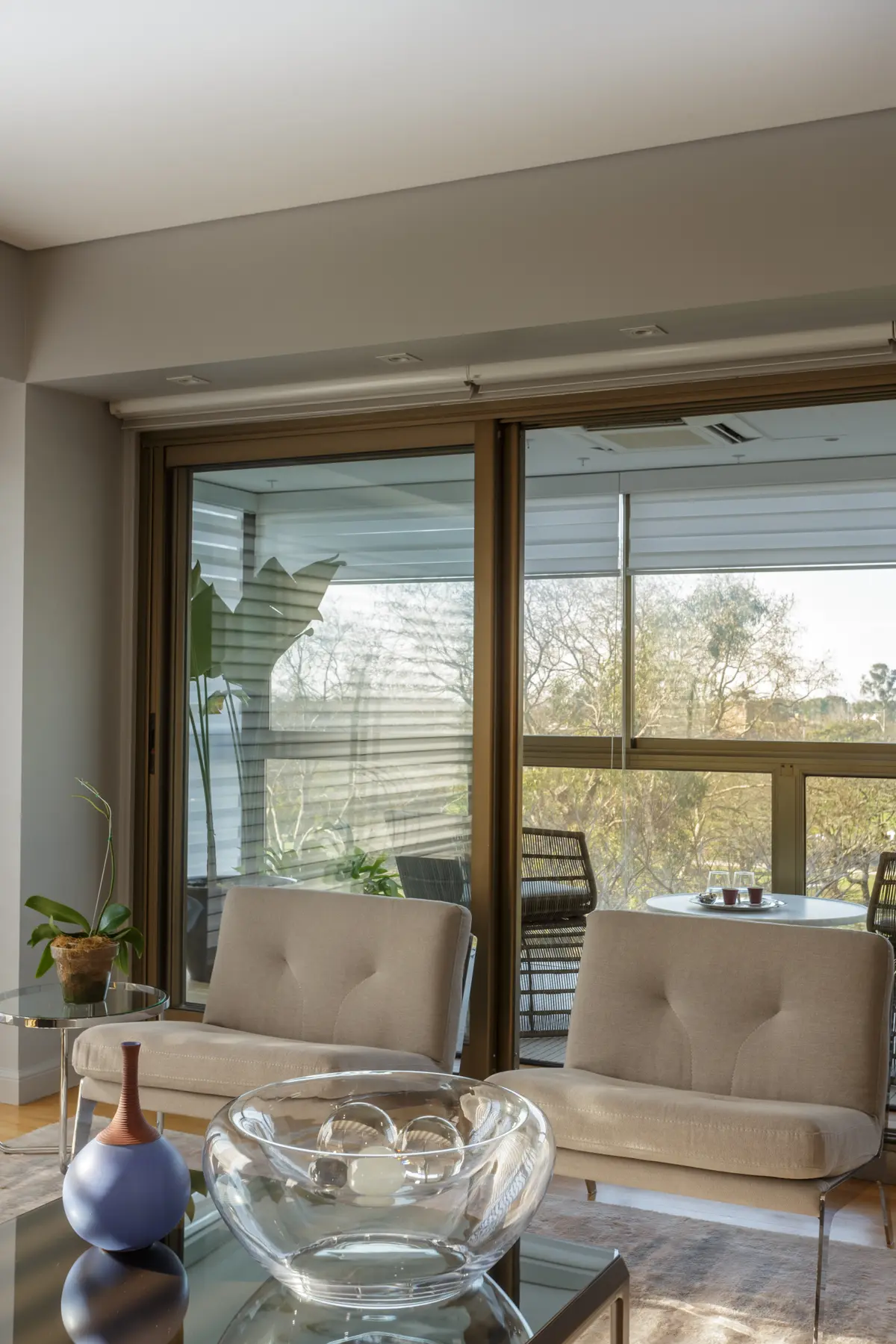 Living moderno con sillones beige y mesa de vidrio — proyecto Piso en Belgrano, por Gutman+Lehrer Arquitectas, en Belgrano