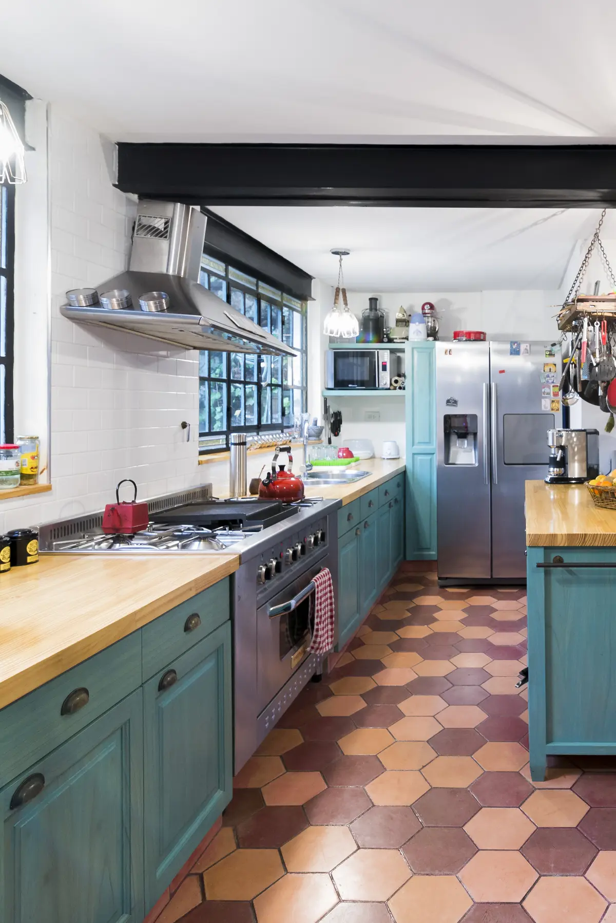 Cozinha rústica com azulejos hexagonais e armários azuis — projeto Gorriti, por ST Arquitectas, em CABA