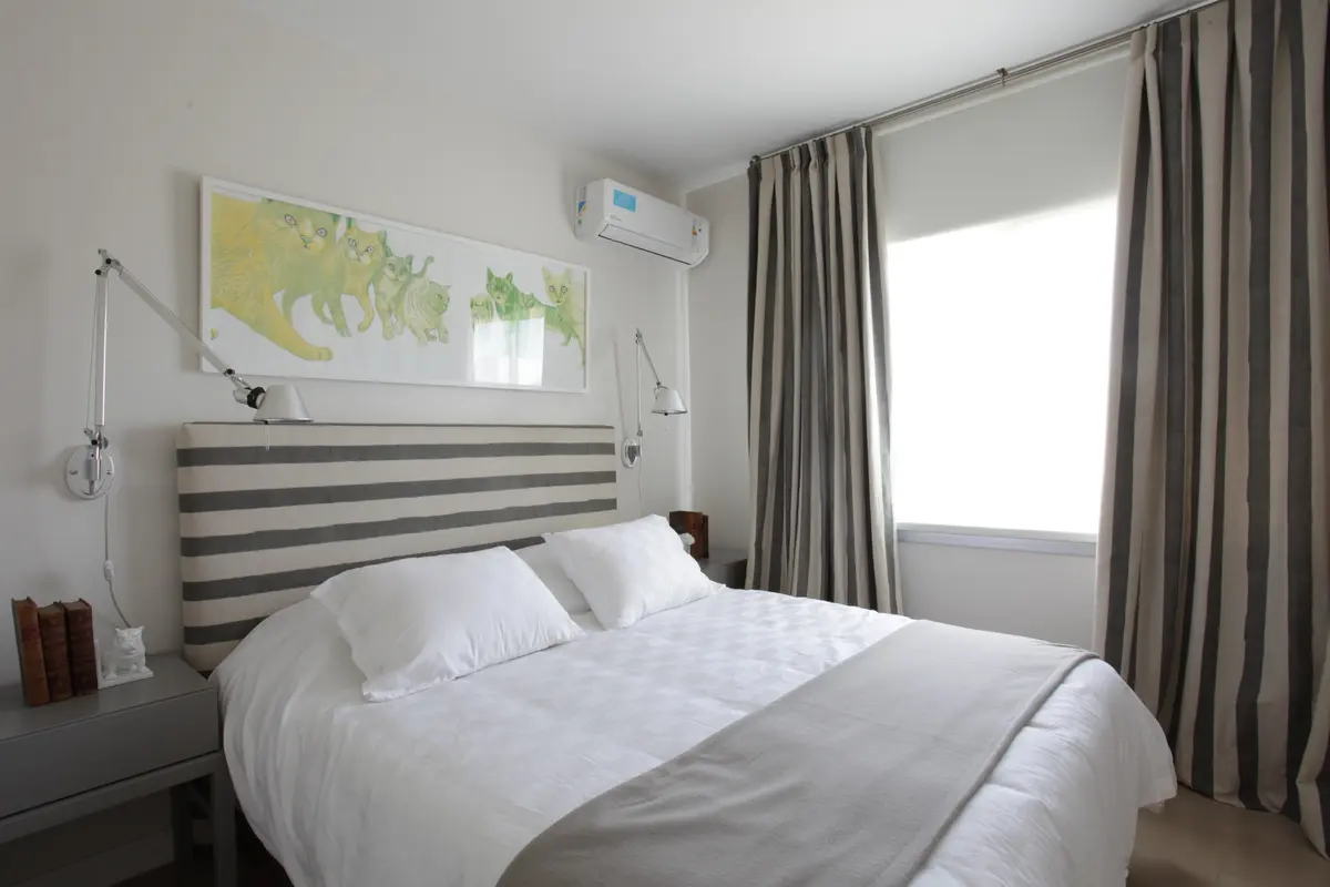 Habitación con cama king, cortinas rayadas y cuadro de mapa — proyecto Casa Nordelta, por M. Beatriz Gonzalez Zuelgaray, en Nordelta