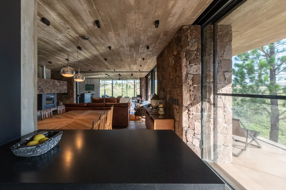 Sala de estar moderna rústica com pedra e concreto aparente — projeto Vivienda Tanti, por Estudio Qf, em Tanti
