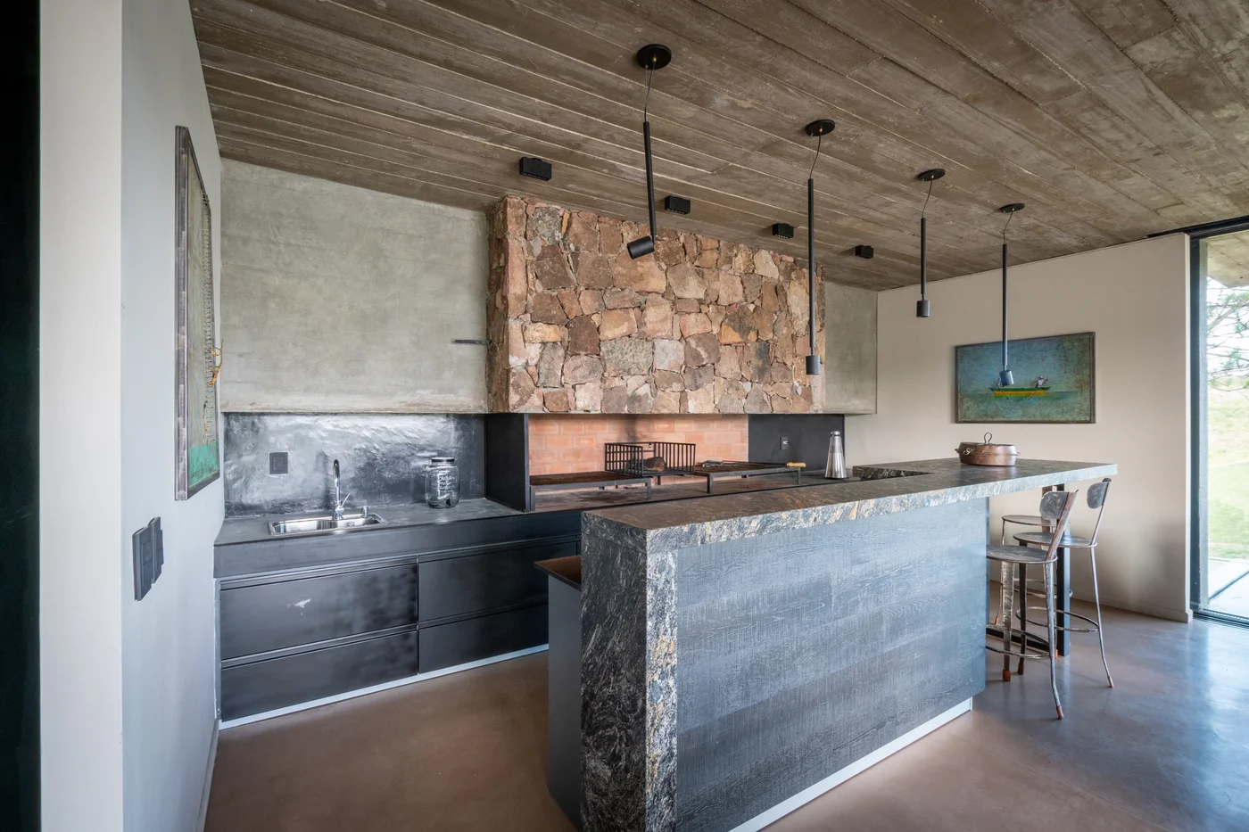 Cocina moderna con isla de piedra y techo de hormigón